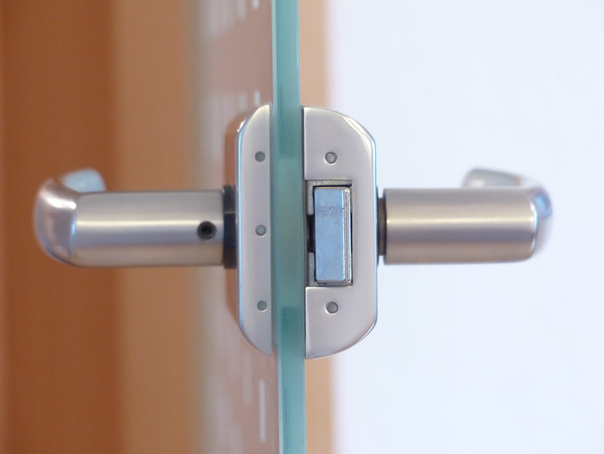 Close-up of modern glass door handle and lock mechanism