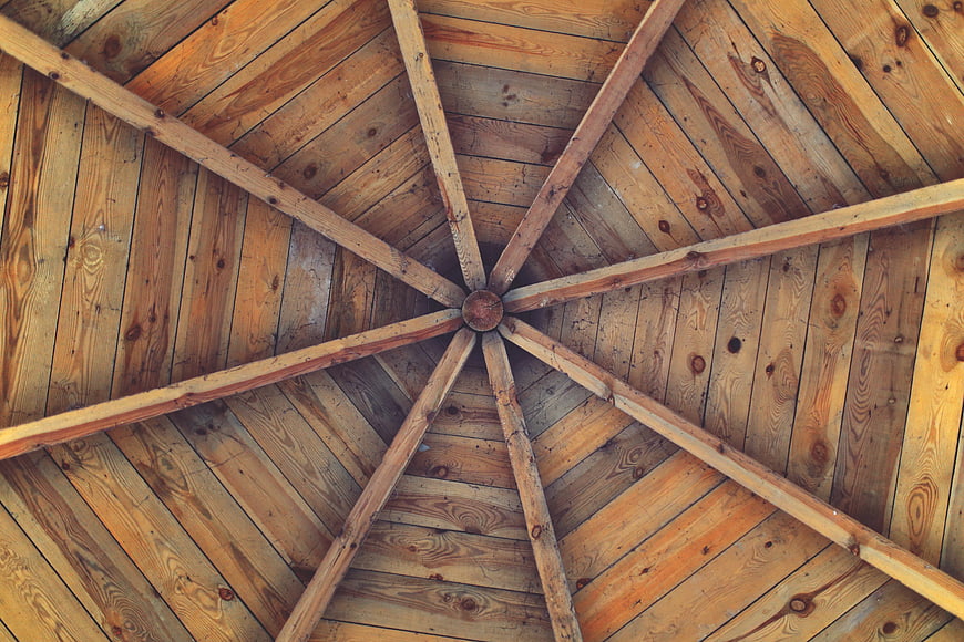 Wooden gazebo ceiling with radial beams and planks