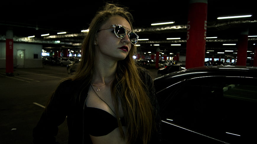 Stylish Woman in Sunglasses Standing in Parking Garage
