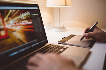 Graphic Designer Using Graphics Tablet and Laptop