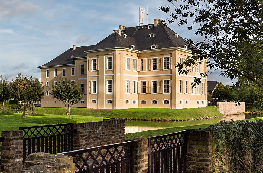 Historic yellow castle with moat and bridge in Miel, Swisttal