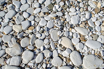 Close-up of smooth white pebbles and stones on a beach