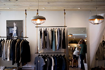 Modern Clothing Store Interior with Hanging Racks and Shoppers