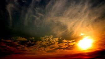 Dramatic sunset with swirling clouds and bright sun