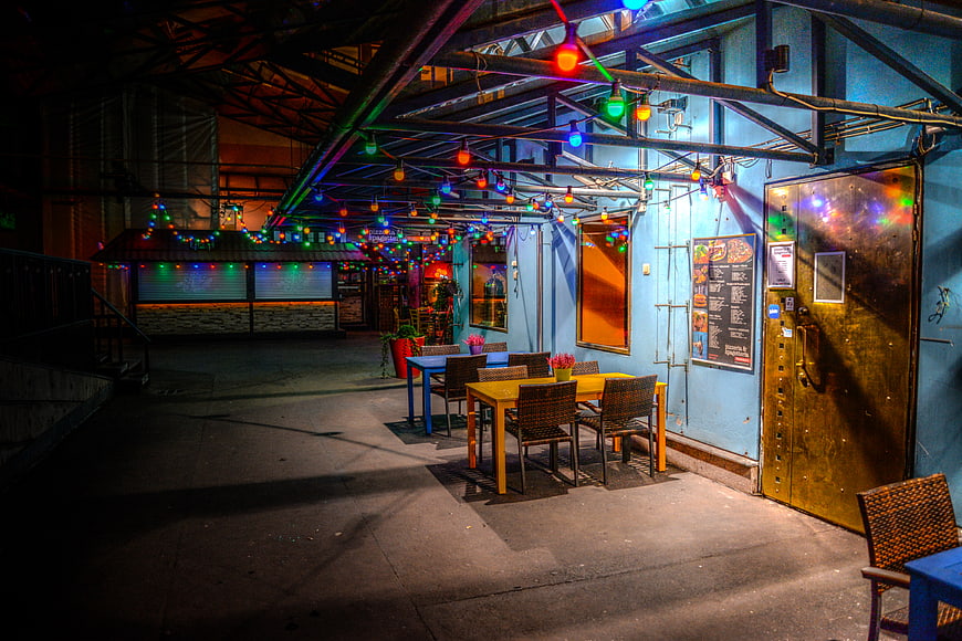 Empty outdoor restaurant patio with colorful string lights at night