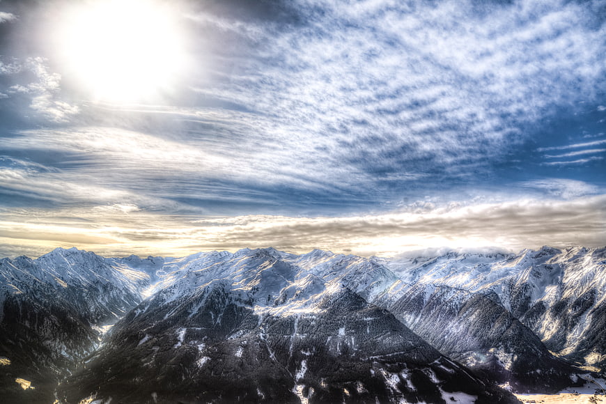 Majestic Snow-Covered Mountain Range Under Dramatic Sky