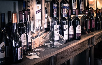 Wine bottles and decanter on rustic wooden shelf