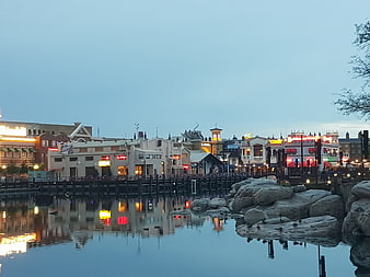 Evening waterfront cityscape with illuminated buildings and reflections
