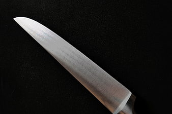 Sharp stainless steel knife blade close-up on black background