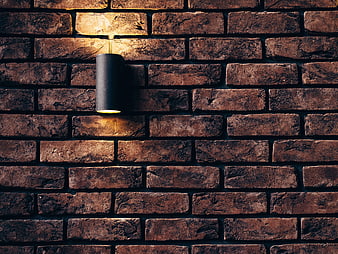 Modern black sconce on textured brick wall background