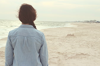 Woman in Denim Shirt Looking Out at Ocean Beach