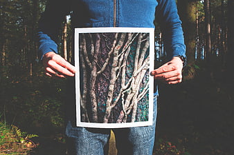 Man holding forest art print in woods