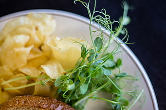 Close-up of Potato Chips and Pea Shoots on a Plate