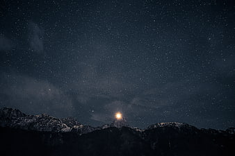 Starry Night Sky Over Snowy Mountain Peaks
