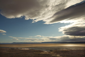 Dramatic desert landscape with vast sky and clouds