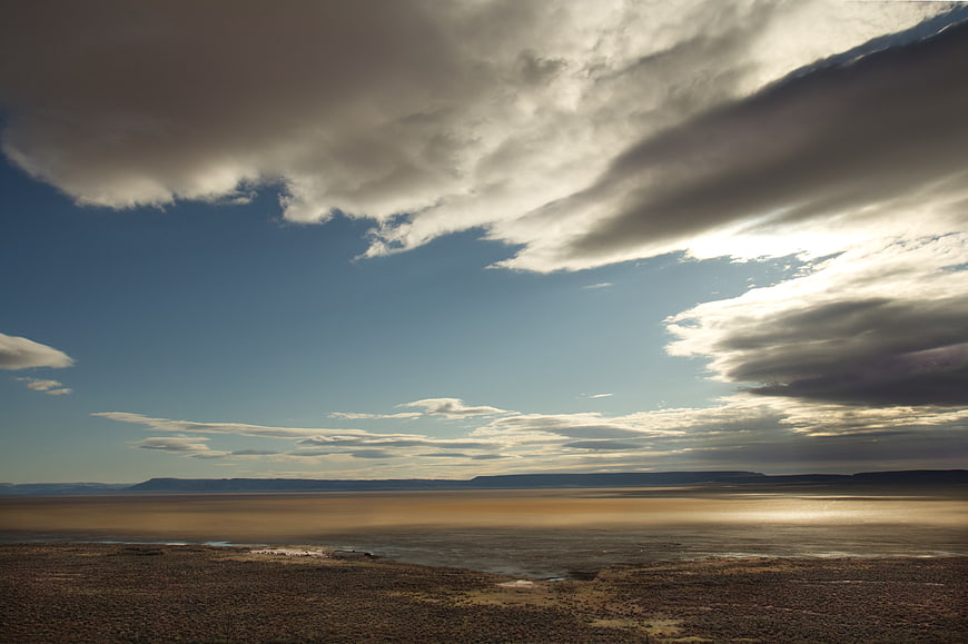 Dramatic desert landscape with vast sky and clouds