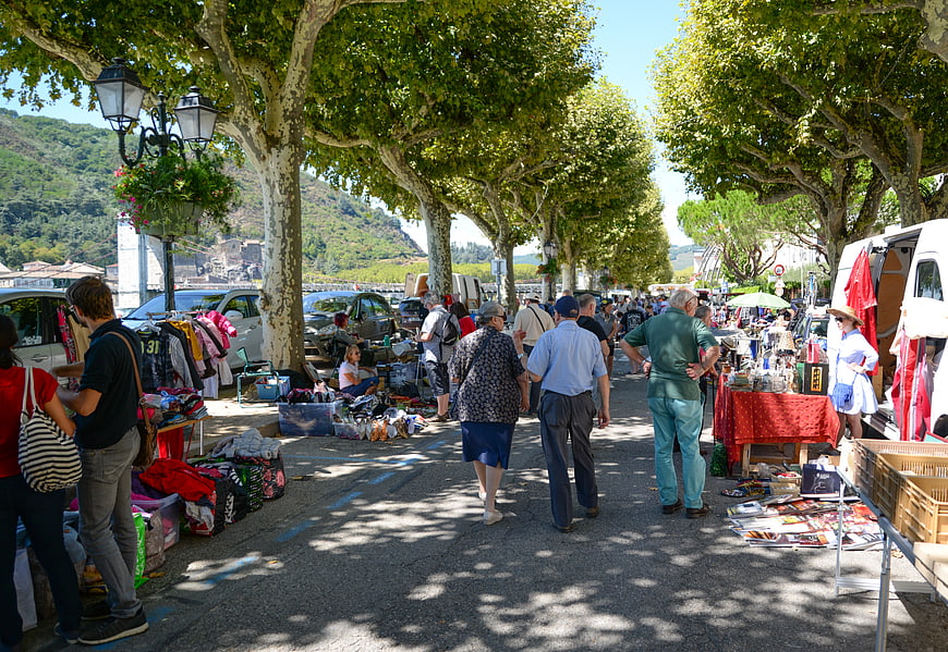 Busy French flea market under tree-lined street