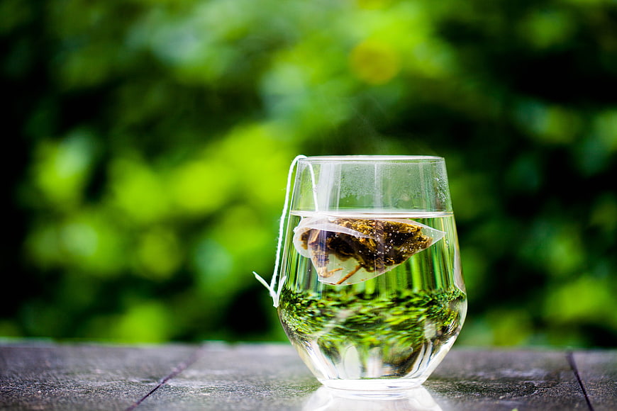 Steaming Green Tea Bag in Glass Cup Outdoors