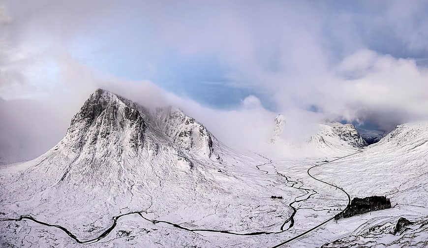 Snow-Covered Mountain Peaks with Winding River and Clouds