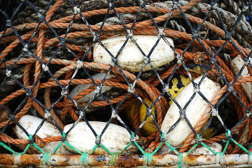Close-up of tangled fishing nets, ropes, and white floats
