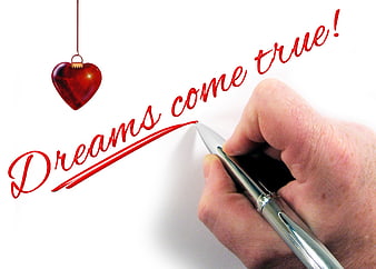 Hand writing dreams come true with red pen and heart