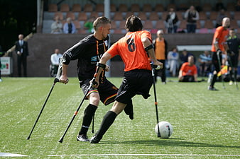 Amputee soccer players competing on grass field
