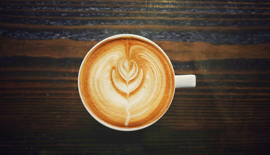 Top View of Latte Art Coffee on Dark Wood Table