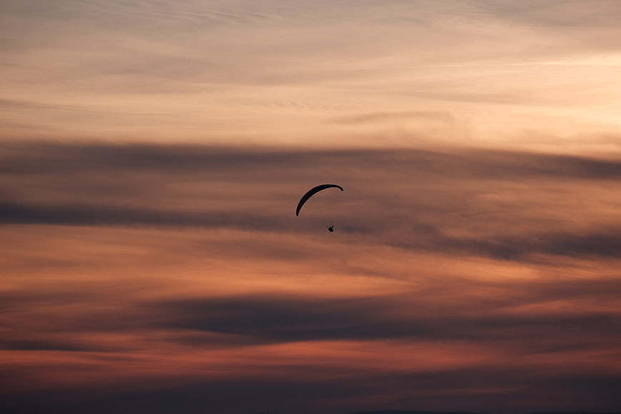 Paraglider Silhouette Against Dramatic Sunset Sky