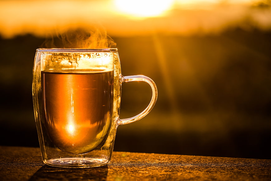 Steaming Hot Tea in Glass Cup at Golden Sunset