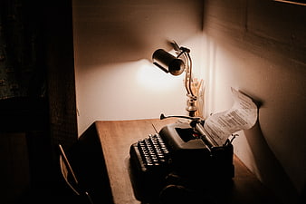 Vintage Typewriter on Wooden Desk with Lamp