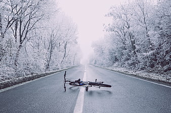 Fallen bicycle on snowy winter road