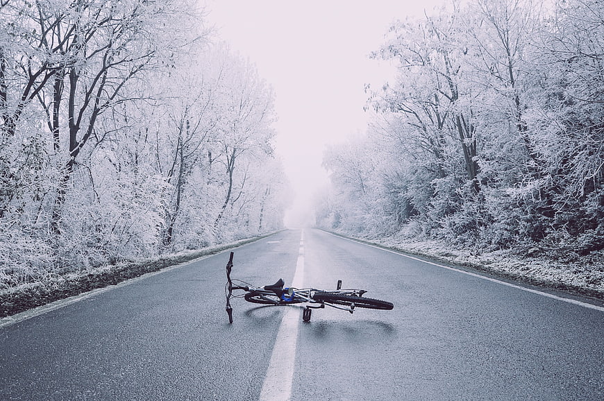 Fallen bicycle on snowy winter road
