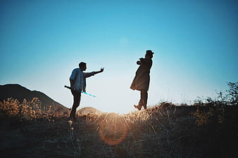 Silhouette of Two Men Dueling with Lightsaber on Hilltop