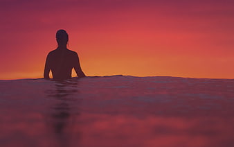 Woman Silhouette in Ocean at Vibrant Sunset