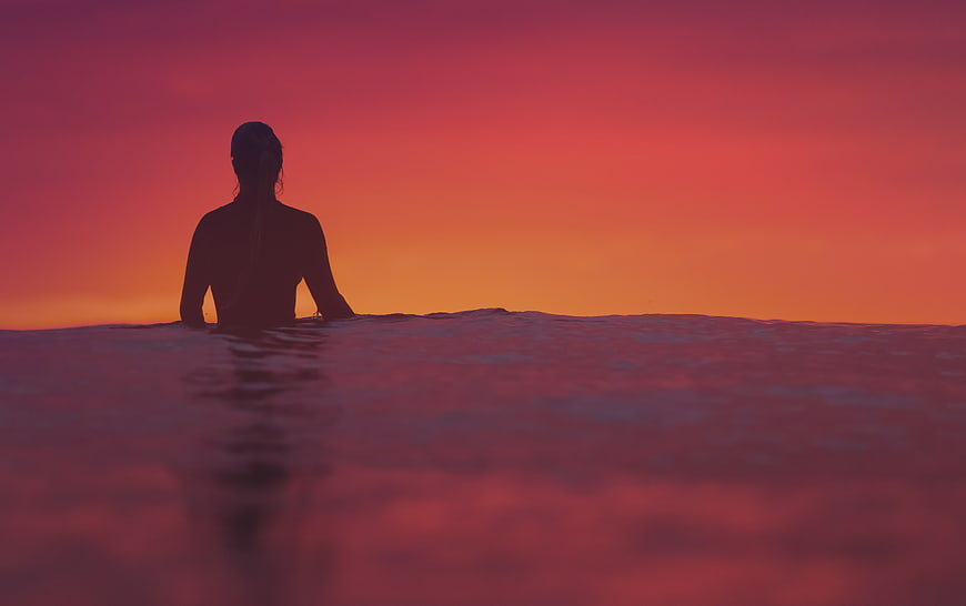 Woman Silhouette in Ocean at Vibrant Sunset