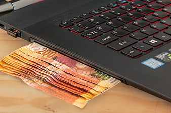 Euro banknotes emerging from laptop USB port
