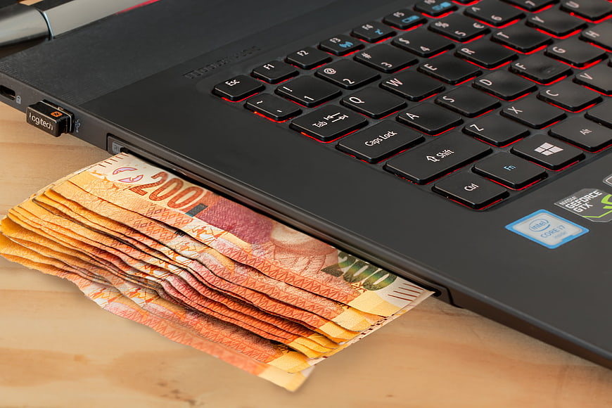 Euro banknotes emerging from laptop USB port