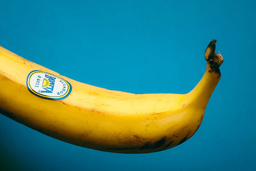 Yellow Banana with Sticker on Blue Background