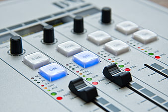 Close-Up of Professional Audio Mixing Console Faders and Knobs