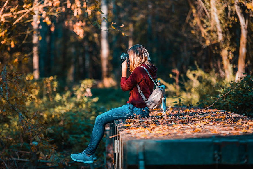 Woman Photographer Taking Pictures in Autumn Forest