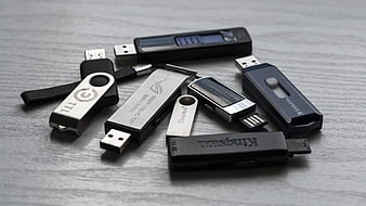 Collection of various USB flash drives on gray wood