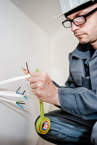 Electrician repairing electrical wires with screwdriver