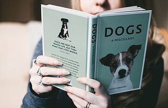 Woman Reading Book About Dogs with Cute Puppy Cover