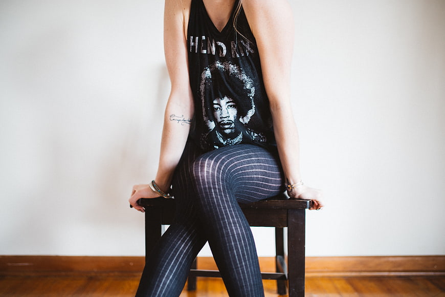 Woman in Jimi Hendrix Tank Top Sitting on Wooden Chair