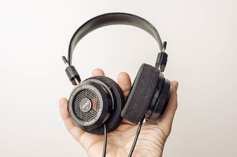 Hand holding black Grado Prestige Series headphones