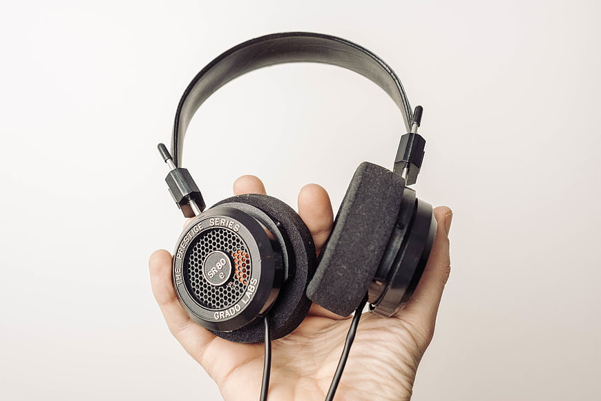 Hand holding black Grado Prestige Series headphones