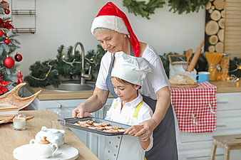 Grandmother and granddaughter baking Christmas cookies in festive kitchen