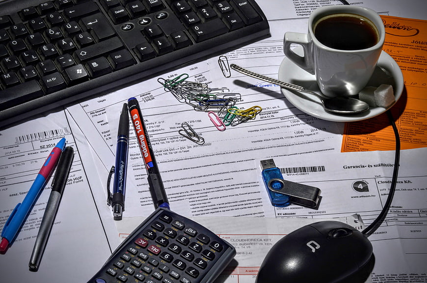 Accountant workspace with calculator, coffee, keyboard, and financial documents