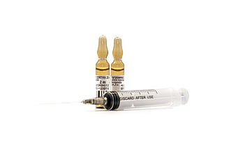 Medical syringe and two amber vials isolated on white background