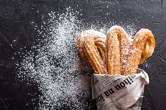 Churros with Powdered Sugar on Dark Background